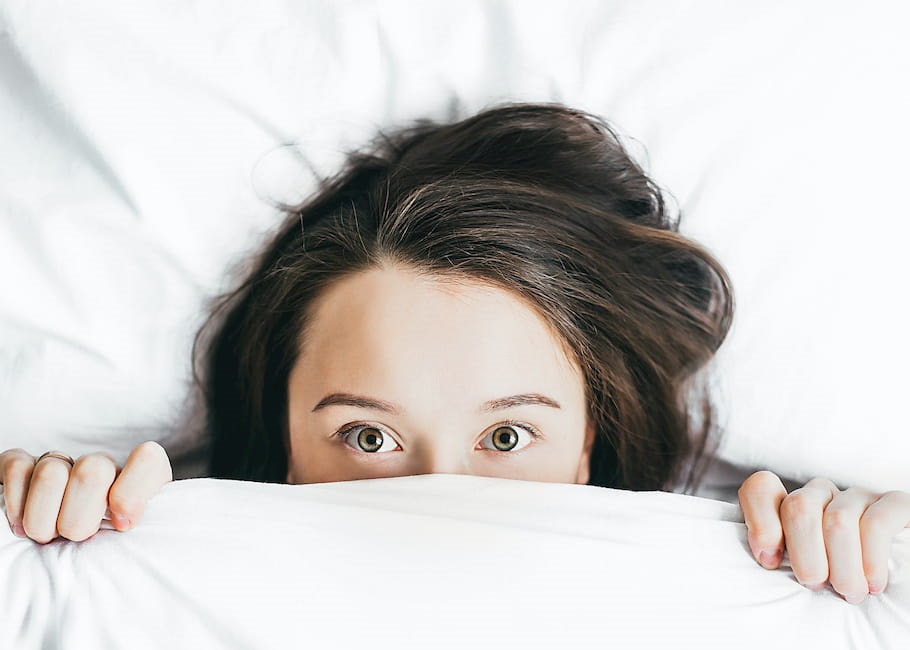 girl-in-bed-in-white-sheet-hiding