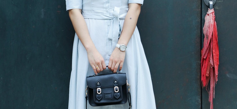 picture of a person wearing dress, with watch and hand bag 