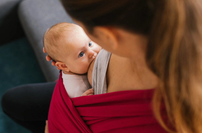 picture of a woman breastfeeding a baby in a babywearing 