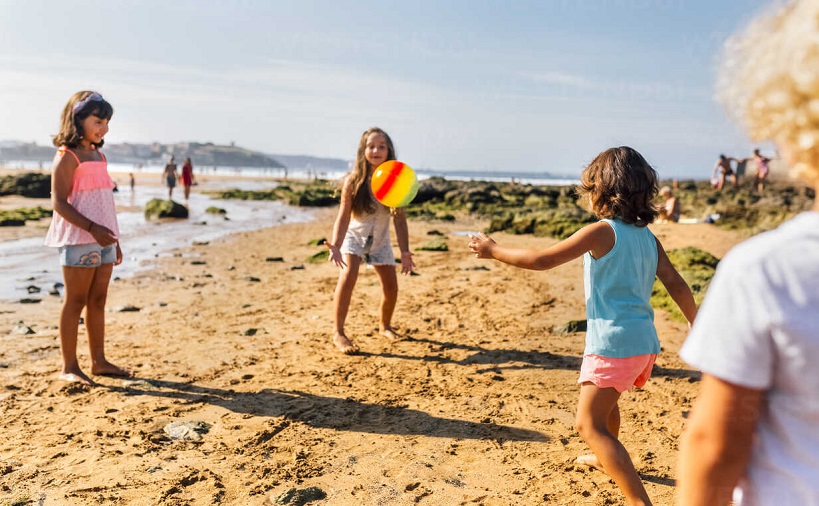  group of kids playing on the beach